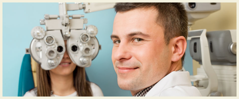 male optometrist giving eye exam